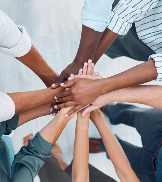 istockphoto-1448698612-612×612 Diversity, hands and team above in support, trust and unity for collaboration, agreement or meeting at the office. Group hand of diverse people in teamwork, cooperation and solidarity for community